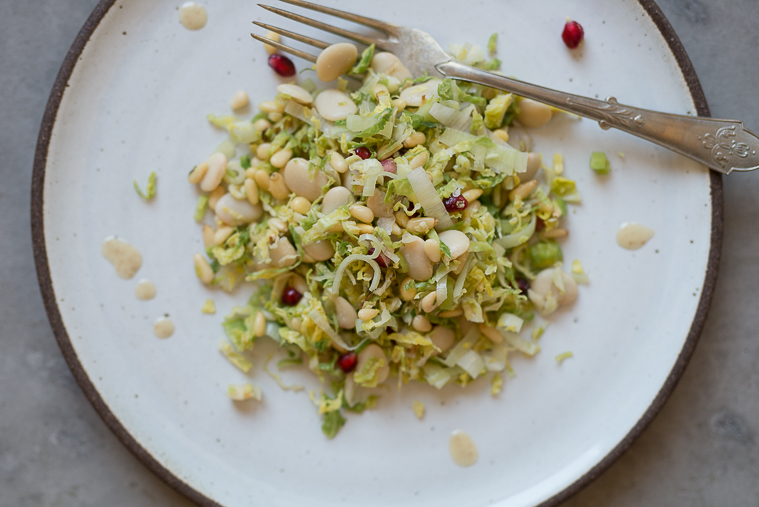 warm winter brussel sprouts and butter bean salad with leeks, pomegranates and pine nuts